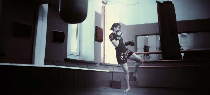 lady performing kick with boxing bag